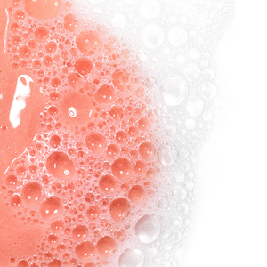 Close-up of foamy pink cleanser bubbles lathered on skin illustrating the cleansing action of AntiBlemish Cleanser | Skin Fitness Therapy for skincare and body care routines.