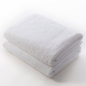 Two neatly folded white towels made from soft, absorbent material, highlighting the plush texture and quality of the Hotel Collection Organic Cotton | TOWL.