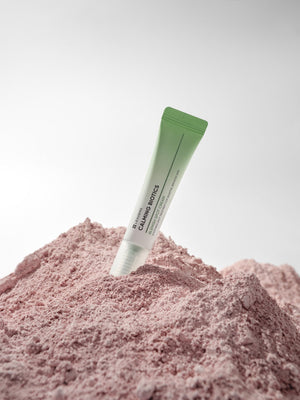 Calming Biotics Blemish Spot Cream | Leaders in a green tube standing upright in soft pink powder, highlighting skincare and wellness care.