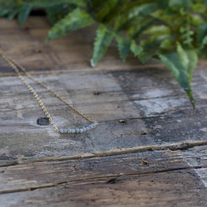 Delicate Diamonds In The Raw Sterling Silver Necklace | Liv & B featuring raw diamonds on a fine silver chain, styled on rustic wooden surface with greenery background.