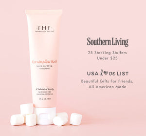 Tube of Marshmallow Melt Hand Cream | Farmhouse Fresh surrounded by white marshmallows on a soft pink background with promotional text for gift ideas and stocking stuffers under $25