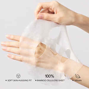 A delicate, translucent sheet mask being gently held and stretched over a hand, showcasing the soft skin-hugging fit of the PDRN 0.5% Lifting Mask | Leaders made with 100% bamboo cellulose and vegan ingredients.