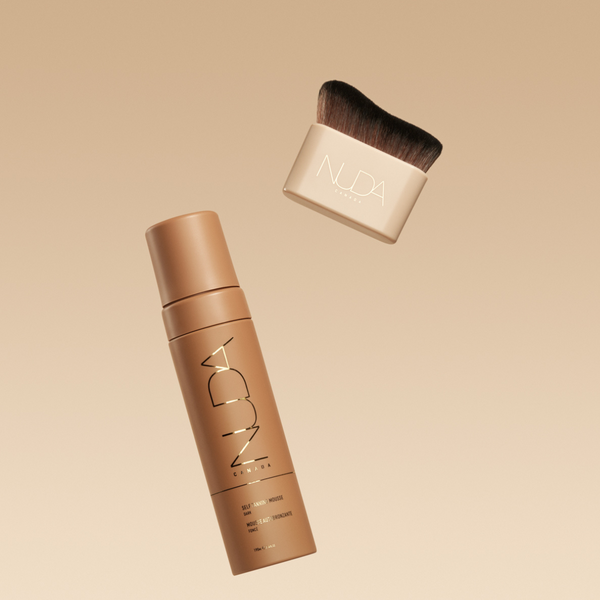 Blending Brush | NUDA with soft, dense bristles and a beige handle paired with a sleek NUDA branded bottle, both designed for flawless skincare and makeup application.