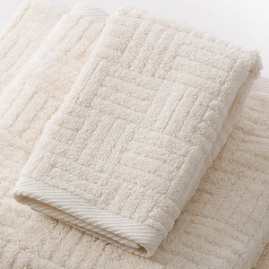 Close-up of a soft, natural-colored towel with a textured geometric pattern made from Hotel Collection Organic Cotton | TOWL, designed for body care and wellness.