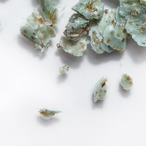 Close-up of crushed pieces of Seaweed Soap | Phytomer showing textured blue-green soap fragments with natural exfoliating particles for skincare and body care use.