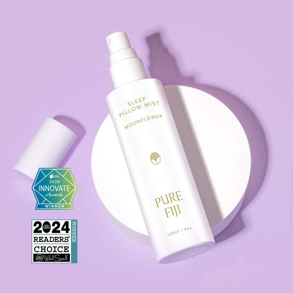White spray bottle of Pillow Mist | Pure Fiji with awards displayed on a lavender background, suggesting a calming and luxurious wellness product for skincare and sleep care.