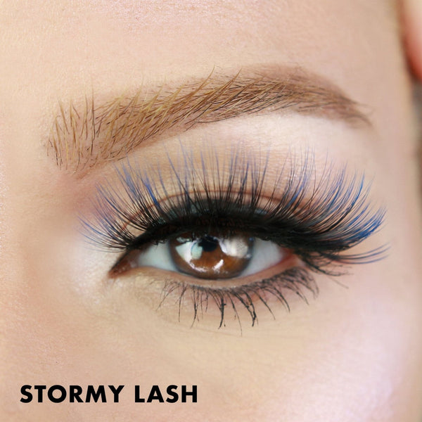 Close-up of a brown eye with long, voluminous black and blue lashes showcasing Stormy Lash - Colored | Moxielash for a bold and dramatic look.