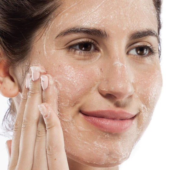 Woman gently applying Finely Awake Plantfoliant Silkening Face Cleansing Polish | Farmhouse Fresh on her face, demonstrating skincare routine for smooth, refreshed skin.