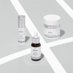 Three IMAGE Skincare AGLESS total eye lift crème | IMAGE Skincare products displayed on a light surface, featuring a pump bottle, dropper bottle, and jar, representing skincare and body care items.
