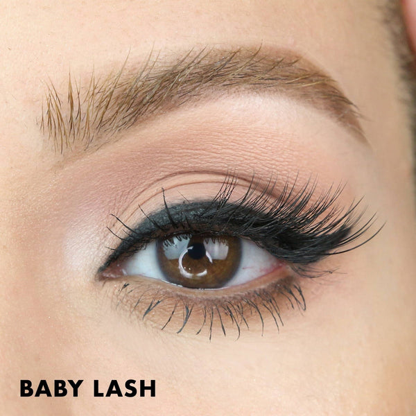 Close-up of a brown eye with long, thick, and curled eyelashes enhanced using Baby Lash | Moxielash, showcasing natural-looking volume and definition for a beauty or skincare focus.