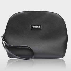 Black textured cosmetic bag with a wrist strap and a Knesko logo, designed to hold the Nanogold Repair Discovery Kit | Knesko for skincare and wellness essentials.