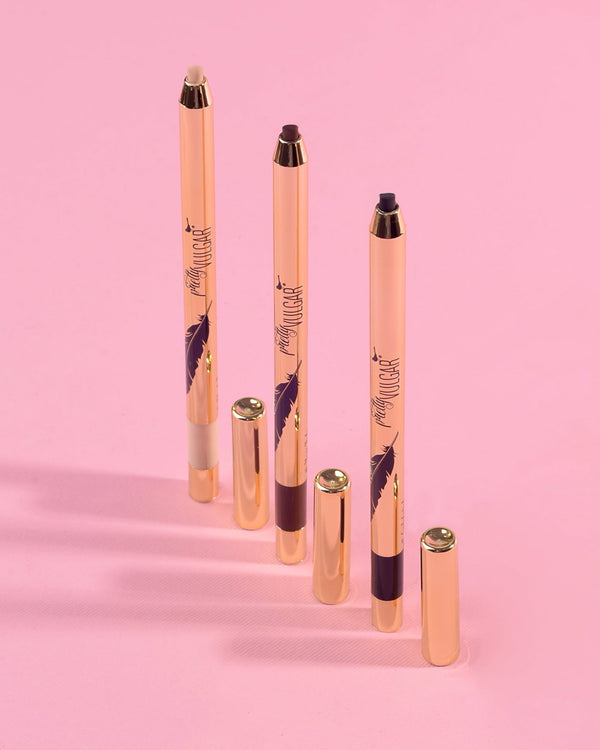 Three Writing on the Wall Eyeliner Pencil | Pretty Vulgar makeup pencils in different shades with rose gold casing and matching caps on a pink background.