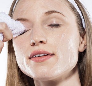Woman gently cleansing her face with a soft cloth, showing a fresh skincare routine using Green Tea Milk Wash | Farmhouse Fresh for a clean and radiant complexion.