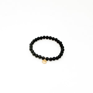 Assorted Satya Bracelets | Satya featuring a single black beaded bracelet with a small gold charm, designed for a stylish and mindful accessory.
