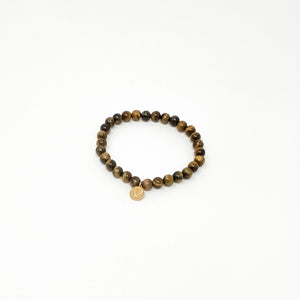 Assorted Satya Bracelets | Satya featuring a round beaded design with natural brown tones and a small circular charm on a white background.