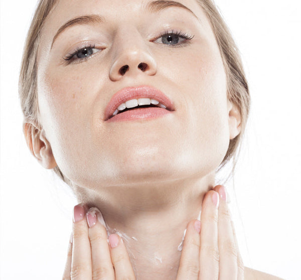 Close-up of a woman gently applying Moon Dip Back To Youth Ageless Body Mousse | Farmhouse Fresh to her neck, showcasing skincare and body care routine for youthful skin.