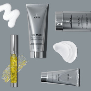 Silver and clear skincare product containers and tubes labeled the MAX™ masque | IMAGE Skincare, with creamy white and golden gel textures on a gray background.