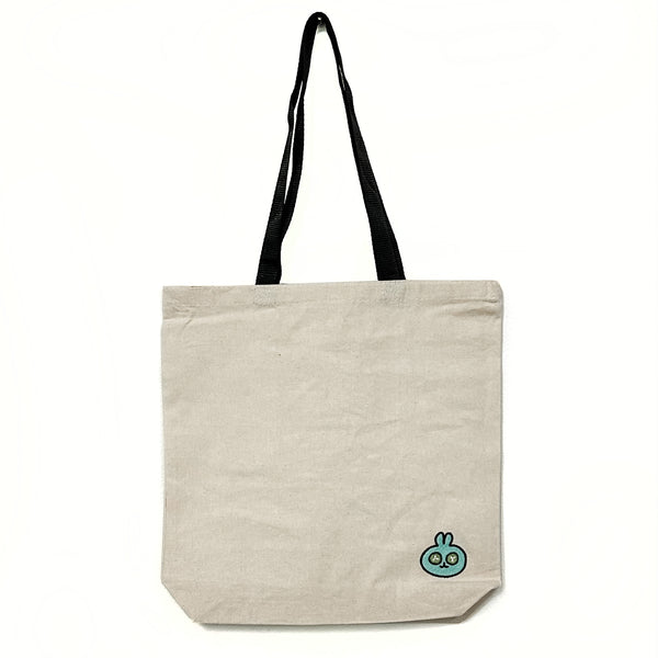 Canvas Totebag - with Embroidered Spa Bunny | Lucky Owl featuring a simple natural canvas material and black handles, decorated with a small embroidered blue bunny design on the lower corner.