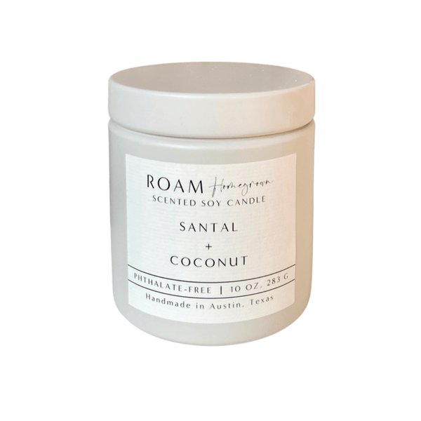 Minimalist white jar candle labeled Santal + Coconut with a clean, modern design, featuring the text "Santal + Coconut 10 oz Candle | ROAM Homegrown" on the label.