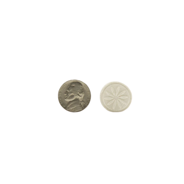 A close-up comparison of a small round white tablet with a floral imprint beside a US nickel coin for size reference, promoting Essential Wipes - Eco Pak (35 wipes) | Functional Botanicals.