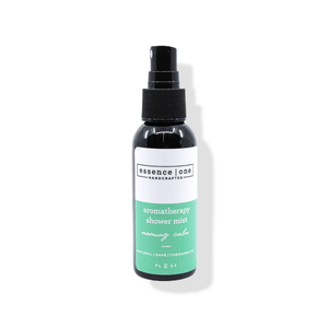 A black spray bottle of Aromatherapy Shower Mist | Essence One with a green and white label, designed for a calming wellness and body care experience.
