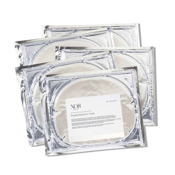 Four silver foil packets of Peptide Radiance Mask | XO8 Cosmeceuticals stacked, highlighting packaging design for skincare and wellness use.