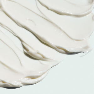 Close-up of smooth creamy white texture swirled on a light surface representing VITAL C hydrating repair crème | IMAGE Skincare moisturizing skincare product.