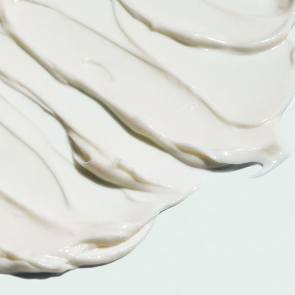Close-up of smooth creamy white texture swirled on a light surface representing VITAL C hydrating repair crème | IMAGE Skincare moisturizing skincare product.
