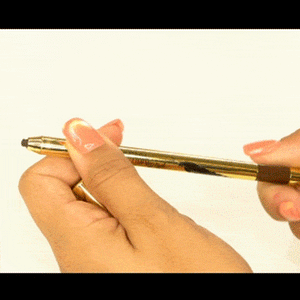 Hand holding and twisting the tip of Writing on the Wall Eyeliner Pencil | Pretty Vulgar with a shiny gold body and dark brown cap.