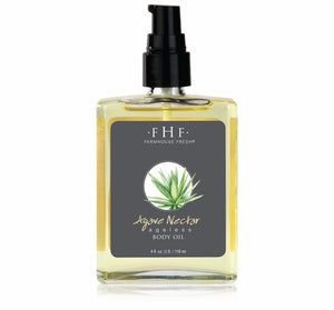 Clear glass bottle with black pump containing yellow body oil, labeled Agave Nectar Ageless Body Oil | Farmhouse Fresh with an agave plant illustration, for skincare and body care.
