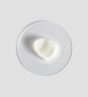 Close-up of a smooth white cream sample on a clear round surface showcasing Remedy Cream | [ comfort zone ] for skincare and body care wellness.