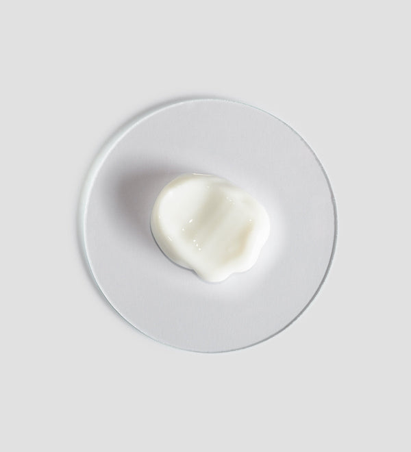 Close-up of a smooth white cream sample on a clear round surface showcasing Remedy Cream | [ comfort zone ] for skincare and body care wellness.