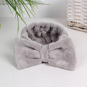 Soft gray plush headband with a bow detail designed for comfort and style in skincare routines, part of the Luxe Spa Headbands | Lucky Owl collection.