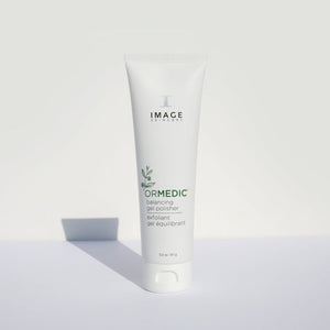 Tube of ORMEDIC balancing gel polisher | IMAGE Skincare with minimalistic white packaging standing upright on a light surface, casting a soft shadow, highlighting a skincare exfoliant product.