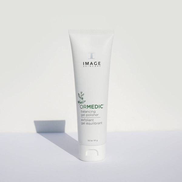 Tube of ORMEDIC balancing gel polisher | IMAGE Skincare with minimalistic white packaging standing upright on a light surface, casting a soft shadow, highlighting a skincare exfoliant product.