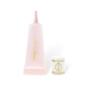 A pink tube of Uncaged Eyeshadow Primer | Pretty Vulgar with a white and gold decorative cap placed beside it on a white background.