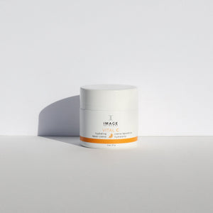 VITAL C hydrating repair crème | IMAGE Skincare in a white container with orange accents, set against a minimalist light background, highlighting skincare and wellness.